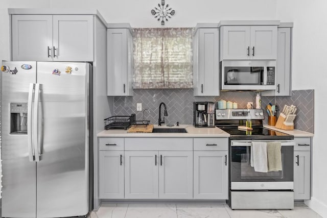 123 Zacate St, Elgin, TX 78621 - kitchen featuring appliances with stainless steel finishes, light marble finish flooring, light countertops, and tasteful backsplash