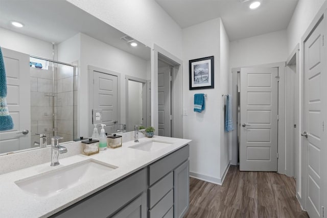 253 Centuryplant Rd, Leander, TX 78641 - bathroom with double vanity, wood finished floors, a stall shower, and recessed lighting