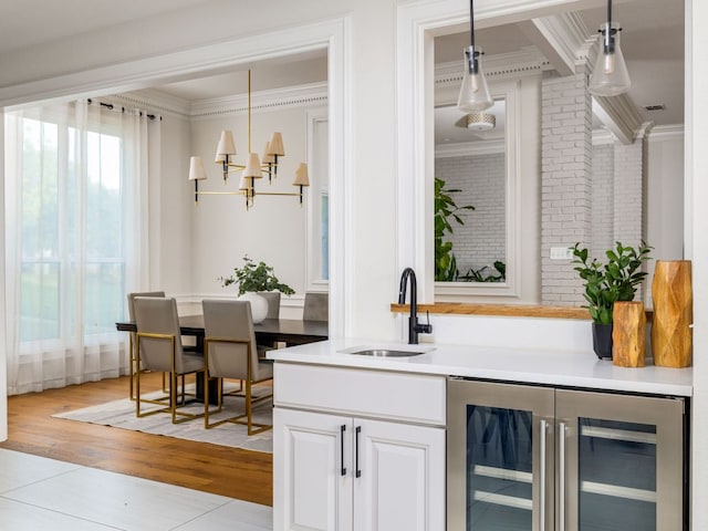 10310 Holme Lacey Ln, Austin, TX 78750 - bar featuring wine cooler, ornamental molding, pendant lighting, a chandelier, and light wood-style floors