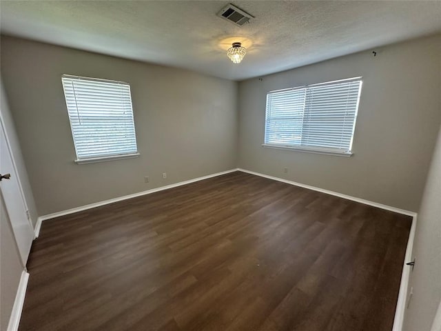 1210 Hi Stirrup Unit 201, Horseshoe Bay, TX 78657 - empty room featuring dark wood finished floors and a textured ceiling