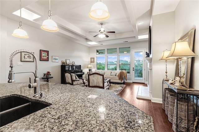 201 Glenfiddich Ln, Austin, TX 78738 - kitchen with stone counters, dark wood-type flooring, a ceiling fan, hanging light fixtures, and beamed ceiling