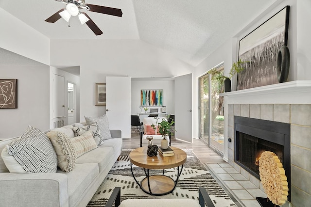 800 Saunders Dr, Round Rock, TX 78664 - living room with a tiled fireplace, vaulted ceiling, a ceiling fan, and light wood-type flooring
