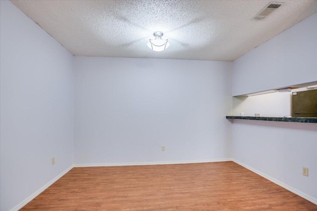 1202 Thorpe Ln Unit 407, San Marcos, TX 78666 - empty room featuring light wood finished floors and a textured ceiling