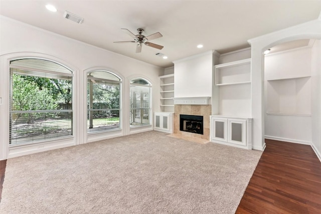 4306 S Summercrest Loop, Round Rock, TX 78681 - unfurnished living room with ceiling fan, a tiled fireplace, crown molding, dark wood-style floors, and recessed lighting