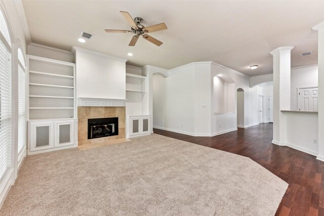 4306 S Summercrest Loop, Round Rock, TX 78681 - unfurnished living room featuring a ceiling fan, a fireplace, dark wood-type flooring, arched walkways, and ornamental molding