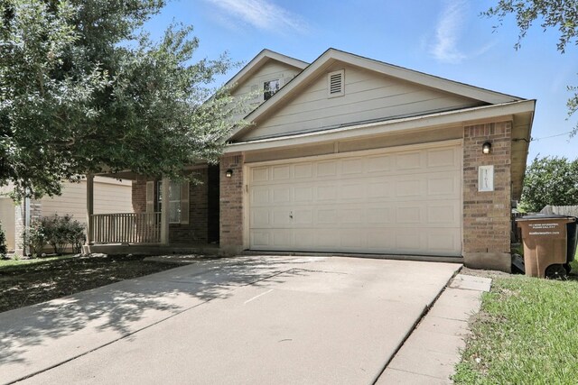 12613 Paloma Blanca Way, Del Valle, TX 78617 - view of front of house featuring brick siding, driveway, an attached garage, and a porch