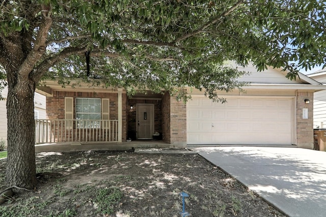 12613 Paloma Blanca Way, Del Valle, TX 78617 - view of property hidden behind natural elements with brick siding, concrete driveway, covered porch, and an attached garage