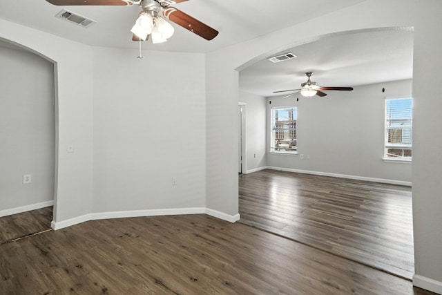 12613 Paloma Blanca Way, Del Valle, TX 78617 - spare room with a ceiling fan, arched walkways, healthy amount of natural light, and dark wood-type flooring