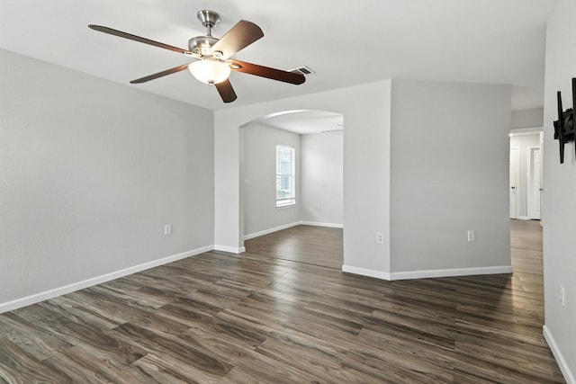 12613 Paloma Blanca Way, Del Valle, TX 78617 - spare room featuring arched walkways, ceiling fan, and dark wood-style flooring