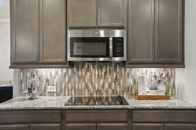 5106 La Piedra Ln, Killeen, TX 76549 - kitchen with stainless steel microwave, black electric cooktop, tasteful backsplash, and dark brown cabinetry