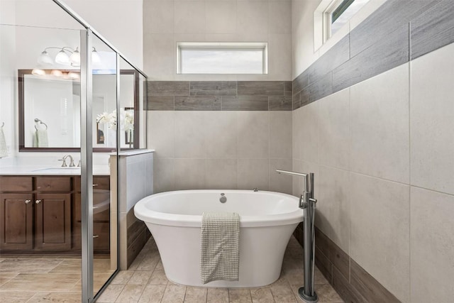 105 Quiet Oak Cv, Liberty Hill, TX 78642 - bathroom featuring a freestanding bath, tile walls, and vanity