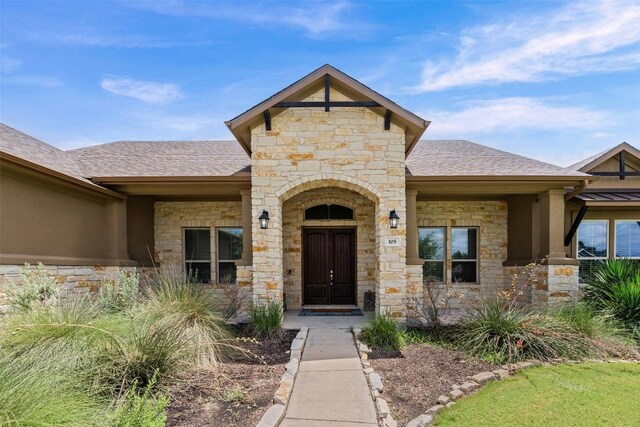 105 Quiet Oak Cv, Liberty Hill, TX 78642 - doorway to property featuring stone siding and roof with shingles