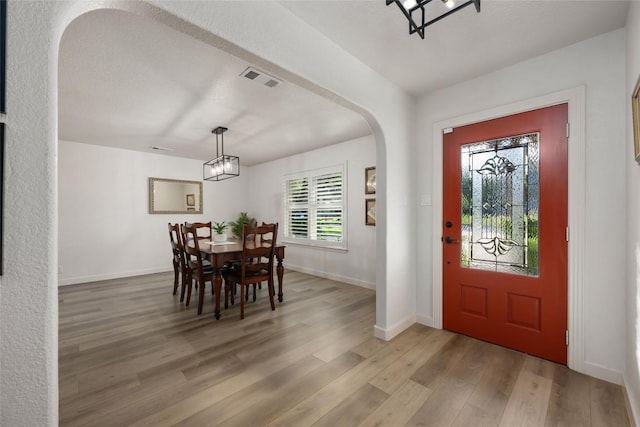 1501 Johnny Miller Trl, Austin, TX 78746 - foyer featuring light wood-type flooring, arched walkways, and a chandelier
