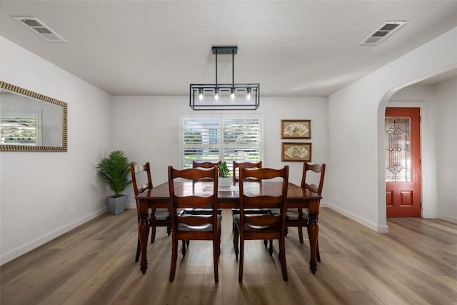 1501 Johnny Miller Trl, Austin, TX 78746 - dining space featuring light wood-style floors and arched walkways