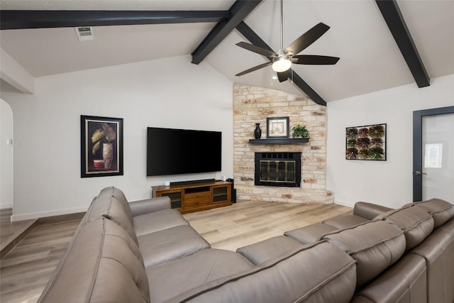 1501 Johnny Miller Trl, Austin, TX 78746 - living area featuring wood finished floors, ceiling fan, a stone fireplace, and arched walkways
