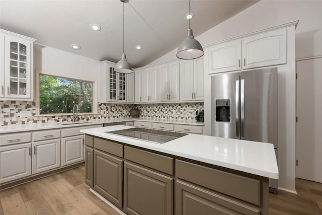 1501 Johnny Miller Trl, Austin, TX 78746 - kitchen featuring black electric stovetop, vaulted ceiling, light wood-style flooring, backsplash, and light countertops