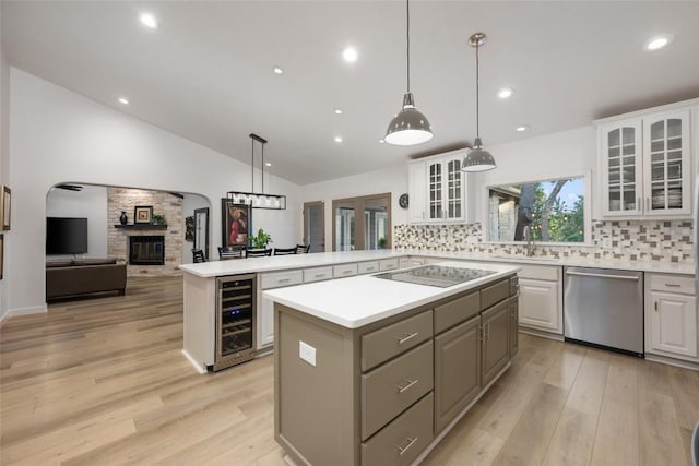 1501 Johnny Miller Trl, Austin, TX 78746 - kitchen featuring dishwasher, beverage cooler, black electric stovetop, a kitchen island, and light countertops