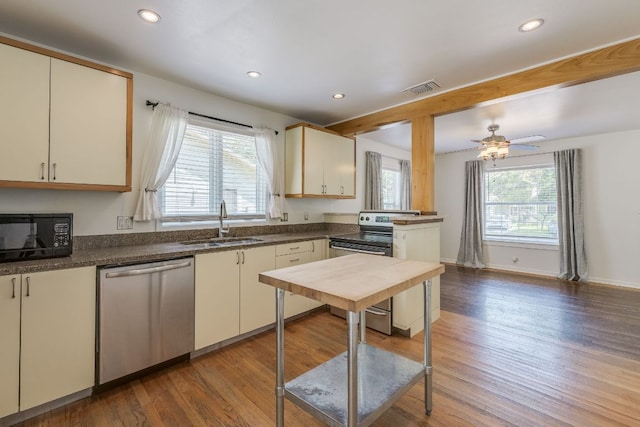1901 Madison Ave, Austin, TX 78757 - kitchen with appliances with stainless steel finishes, wood finished floors, dark countertops, recessed lighting, and beamed ceiling