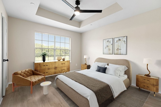 9201 Brodie Ln Unit 1002, Austin, TX 78748 - bedroom featuring wood finished floors, a raised ceiling, and ceiling fan