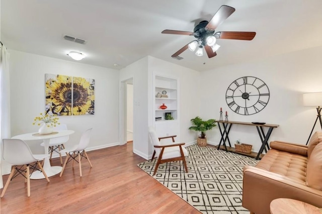 504 Denson Dr, Austin, TX 78752 - sitting room featuring built in features, wood finished floors, and a ceiling fan