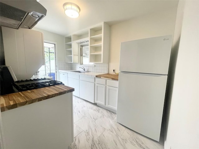 504 Denson Dr, Austin, TX 78752 - kitchen featuring white appliances, exhaust hood, wooden counters, and light marble finish floors