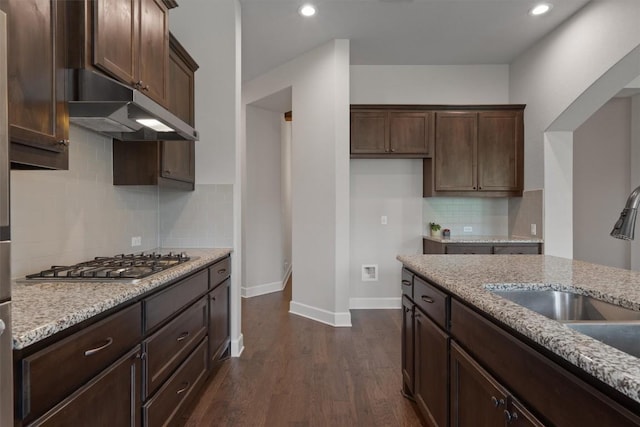 416 Hereford Loop, Hutto, TX 78634 - kitchen with stainless steel gas cooktop, dark wood-type flooring, under cabinet range hood, light stone counters, and recessed lighting