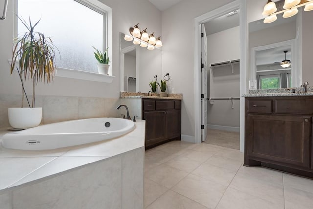 416 Hereford Loop, Hutto, TX 78634 - full bathroom featuring two vanities, a garden tub, tile patterned flooring, and ceiling fan