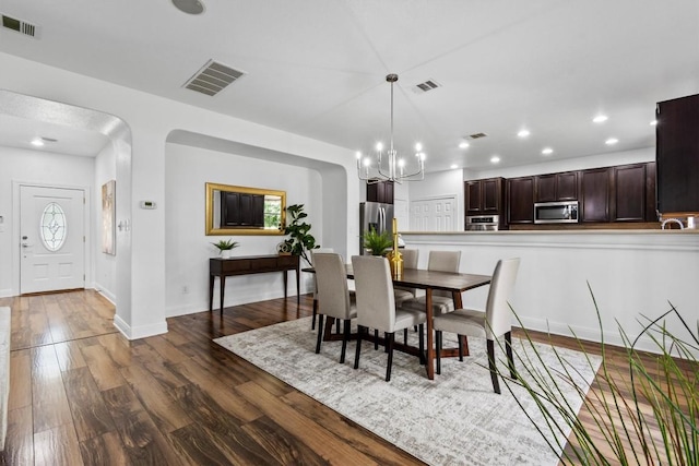 2003 Woodway Dr, Leander, TX 78641 - dining space with a chandelier, dark wood-style floors, recessed lighting, and arched walkways