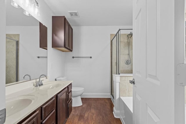 2003 Woodway Dr, Leander, TX 78641 - full bathroom featuring a shower stall, double vanity, a bath, and wood finished floors