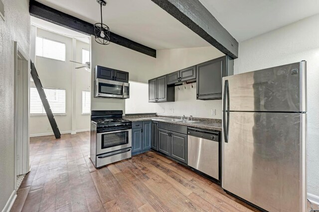 1010 W 23rd St Unit 2, Austin, TX 78705 - kitchen featuring appliances with stainless steel finishes, wood finished floors, a ceiling fan, gray cabinetry, and decorative light fixtures