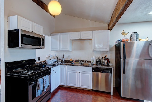 1010 W 23rd St Unit 2, Austin, TX 78705 - kitchen featuring appliances with stainless steel finishes, lofted ceiling, dark wood-style floors, white cabinets, and dark stone countertops