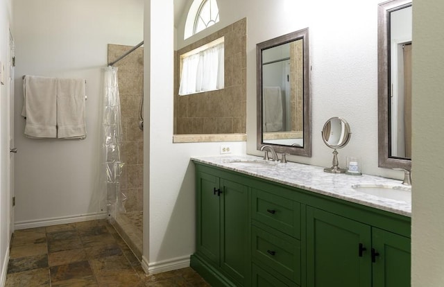 1805 Sequoia Dr, Leander, TX 78641 - bathroom featuring double vanity, tiled shower, and stone finish flooring
