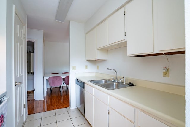 6903 Deatonhill Dr Unit 19, Austin, TX 78745 - kitchen with light tile patterned floors, stainless steel dishwasher, light countertops, and white cabinetry