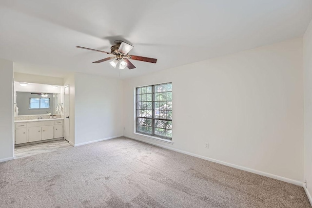 9504 Hansford Dr, Austin, TX 78753 - unfurnished bedroom with light colored carpet, connected bathroom, and a ceiling fan