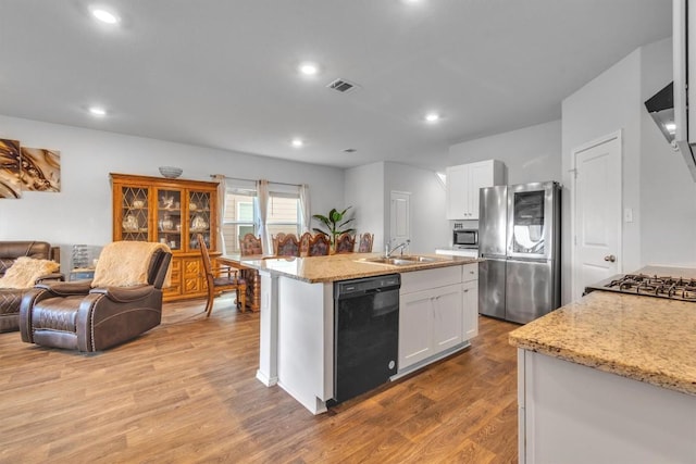 2961 Brogan Crk, New Braunfels, TX 78130 - kitchen with appliances with stainless steel finishes, open floor plan, wood finished floors, white cabinetry, and light stone countertops