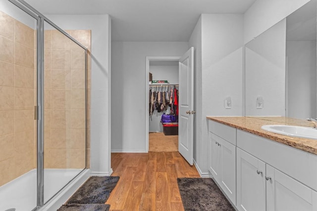 2961 Brogan Crk, New Braunfels, TX 78130 - full bathroom featuring vanity, a stall shower, wood finished floors, and a spacious closet