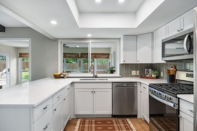1406 Radam Cir, Austin, TX 78745 - kitchen featuring appliances with stainless steel finishes, healthy amount of natural light, light tile patterned floors, a peninsula, and recessed lighting