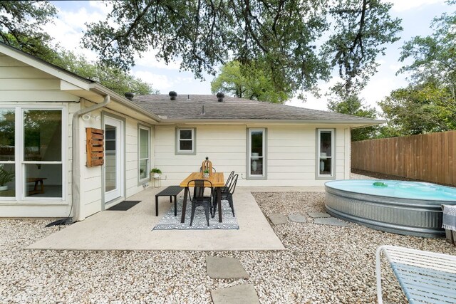 1406 Radam Cir, Austin, TX 78745 - back of property featuring an outdoor hot tub, a patio, and roof with shingles