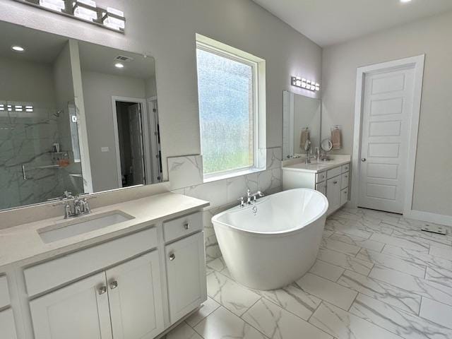 900 Elenora Dr, Leander, TX 78641 - full bathroom featuring marble finish floors, vanity, a shower stall, a freestanding tub, and recessed lighting