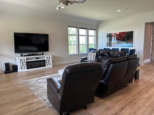 900 Elenora Dr, Leander, TX 78641 - living area with light wood-type flooring, recessed lighting, and a glass covered fireplace