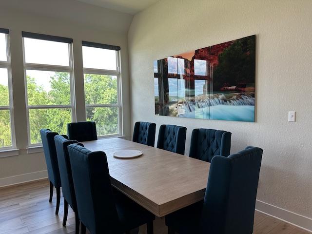 900 Elenora Dr, Leander, TX 78641 - dining area featuring wood finished floors, healthy amount of natural light, and vaulted ceiling