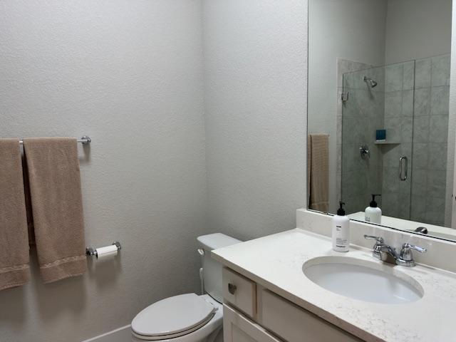 900 Elenora Dr, Leander, TX 78641 - bathroom with vanity, a tile shower, and a textured wall