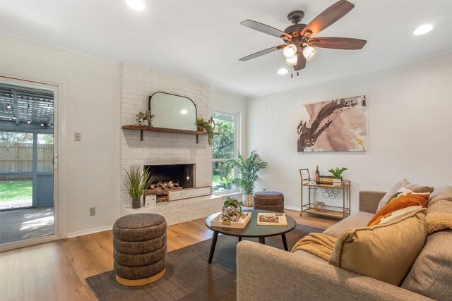 4504 Bilboa Dr, Austin, TX 78759 - living area featuring wood finished floors, ceiling fan, recessed lighting, a brick fireplace, and crown molding