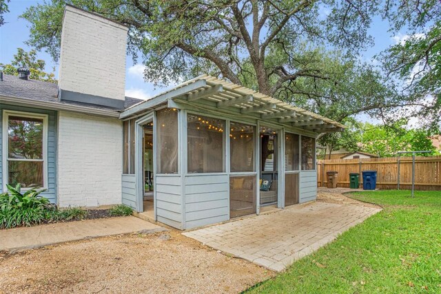 4504 Bilboa Dr, Austin, TX 78759 - exterior space featuring a chimney, a sunroom, brick siding, a pergola, and a patio