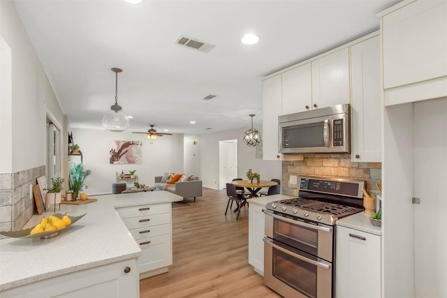4504 Bilboa Dr, Austin, TX 78759 - kitchen featuring stainless steel appliances, decorative backsplash, open floor plan, white cabinetry, and light wood-style floors