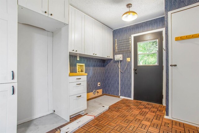 4504 Bilboa Dr, Austin, TX 78759 - laundry area with cabinet space, hookup for a washing machine, wallpapered walls, and a textured ceiling