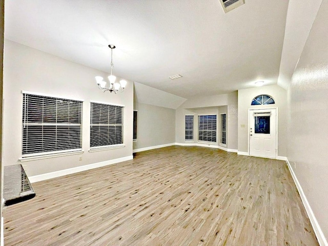 8501 Priest River Dr, Round Rock, TX 78681 - unfurnished living room with wood finished floors, a chandelier, and vaulted ceiling