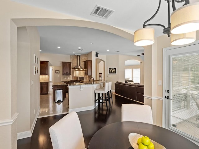 2520 Butler National Dr, Pflugerville, TX 78660 - dining area with arched walkways, dark wood-style floors, and recessed lighting