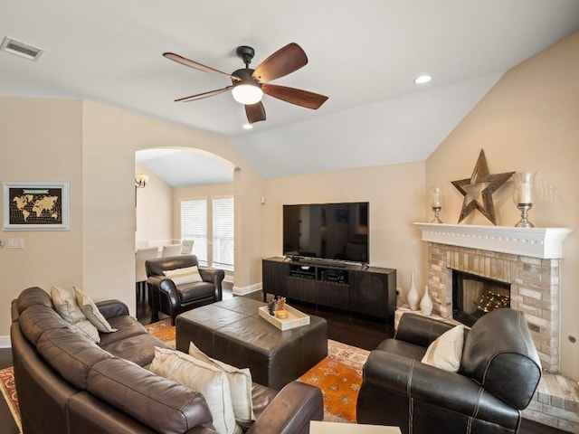 2520 Butler National Dr, Pflugerville, TX 78660 - living room featuring arched walkways, ceiling fan, lofted ceiling, a fireplace, and wood finished floors