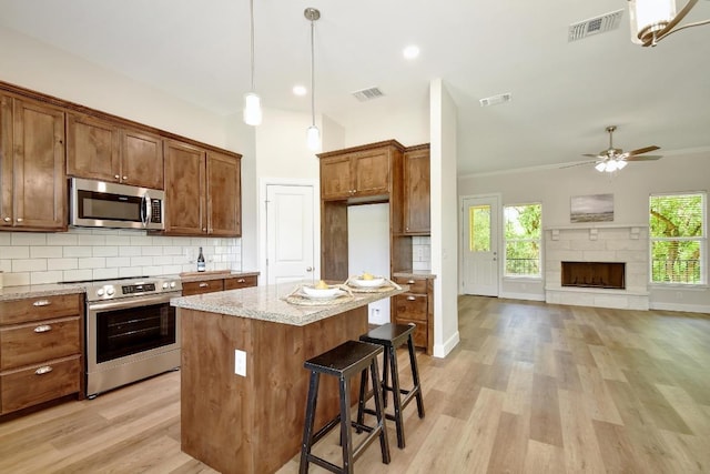 2109 Meadow View Dr, San Marcos, TX 78666 - kitchen with appliances with stainless steel finishes, backsplash, light stone countertops, light wood-style floors, and ornamental molding